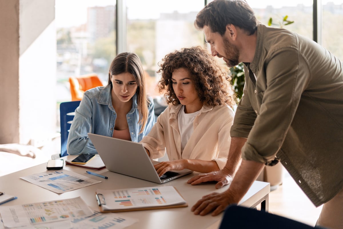 Three HomeSafe team members collaborating in a bright, modern office